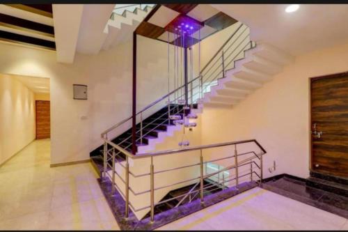 a spiral staircase in a building with a purple light at RROOMS Hotel Riddhi Inn in Lucknow