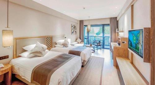 a hotel room with two beds and a flat screen tv at Hotel Dayu Kaiyuan in Shaoxing