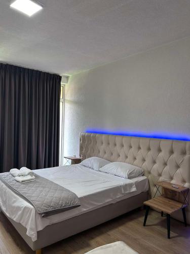 - une chambre dotée d'un lit avec une lumière bleue au-dessus dans l'établissement Beige Apartments, à Struga