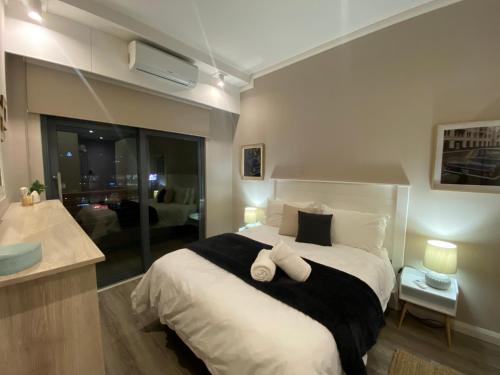 En eller flere senge i et værelse på Menlyn Maine Luxury Apartment