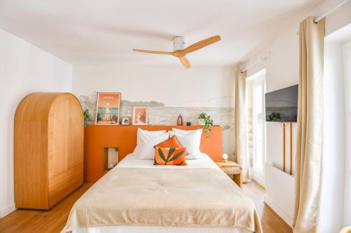 une chambre avec un lit avec un mur orange dans l'établissement Le Glandèves - Appart standing proche Vieux-Port, à Marseille