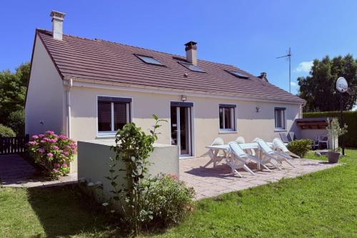 a small white house with a table and chairs at L'Olivier charmante maison avec parking et jardin in Canteleu
