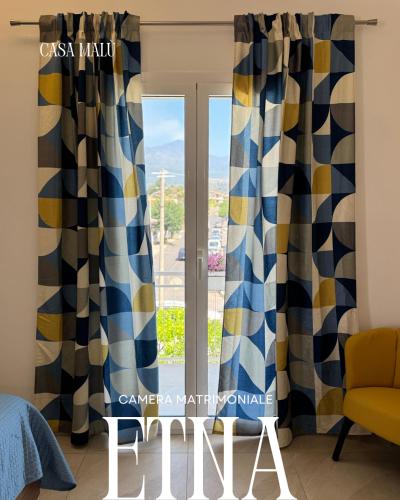 a view from a living room window with curtains at Casa MaLù in Aci Bonaccorsi