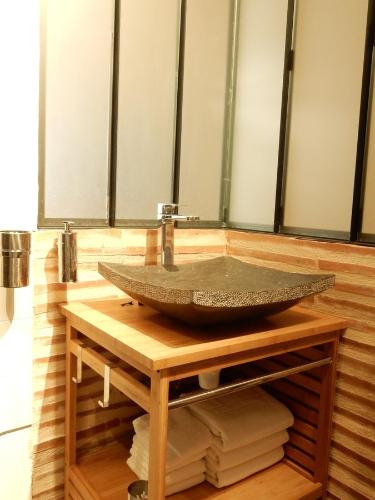 La salle de bains est pourvue d'un lavabo en pierre sur une table en bois. dans l'établissement Coeur de Saint Pierre, à Bordeaux