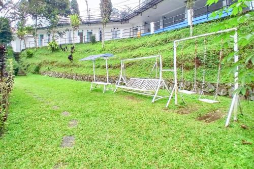 a swing set in the yard of a building at Pangrango Valley Resort RedPartner in Situ 2