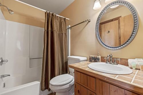 a bathroom with a sink and a toilet and a mirror at Canoe Believe It - Enjoy mountain views cook out on the Weber grill relax in Jasper