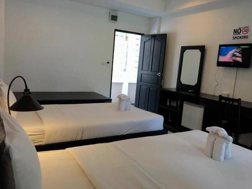 a hotel room with two beds and a television at SP. Place Hotel in Ko Chang