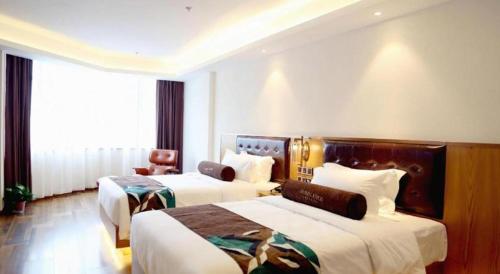 a hotel room with two beds and a chair at James Joyce Coffetel· Hefei Anhui Agricultural University in Hefei