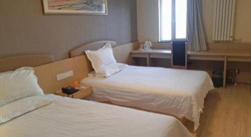 a hotel room with two beds and a window at 7 Days Inn Changchun Zhengyang Street Changchun Park Branch in Changchun