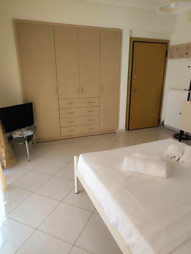 a bedroom with a large white bed and a desk at Flat studio in Loutraki in Loutraki