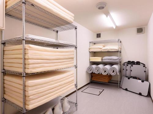 a walk in closet with shelves and towels at La'gent Inn Kesennuma in Higashi-hachimammae