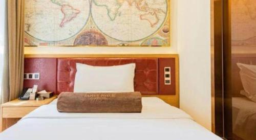 a bed with a wooden headboard with a pillow on it at James Joyce Coffetel Harbin Central Street in Harbin