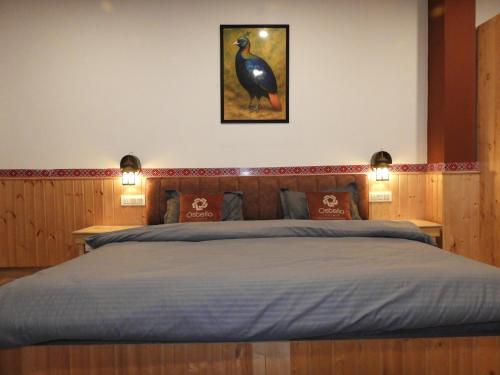 a bedroom with a large bed with two lights at Ostello Tirthan in Bandal