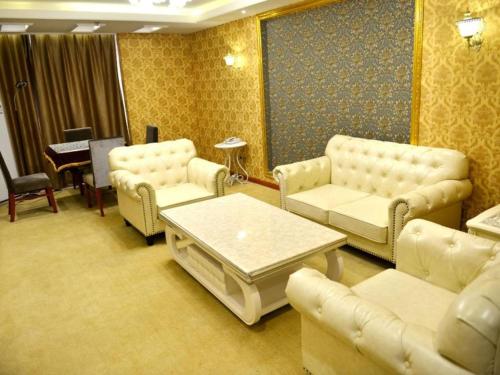 a waiting room with couches and a coffee table at GreenTree Inn Xian Longshouyuan Subway Station Business Hotel in Xi'an