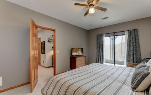 a bedroom with a bed with a ceiling fan and a window at Wanderers Den - Peaceful mountain views Wifi and homey comforts in Jasper