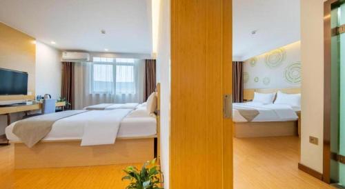a large hotel room with two beds and a desk at GreenTree Inn Huayin Huashan Town Huashan Scenicspot Express Hotel in Huayin