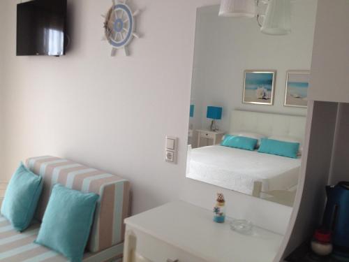 a small bedroom with a mirror and a bed at Spyridonou House in Parga