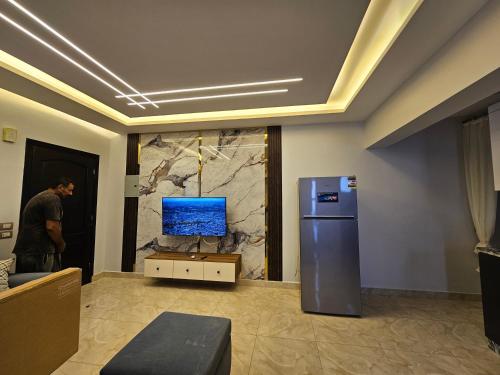 a man is standing in a room with a television at villa 100C A2 in Sharm El Sheikh
