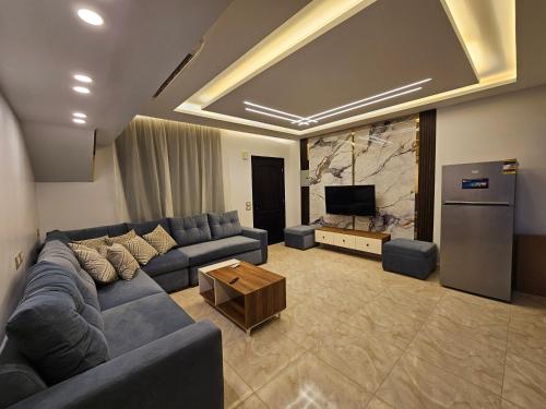 a living room with a blue couch and a television at villa 100C A2 in Sharm El Sheikh