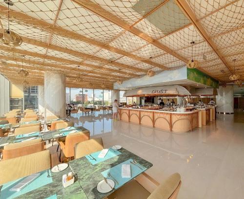 ein Restaurant mit Tischen und Stühlen und einer Theke in der Unterkunft Wyndham Soleil Danang - Free Two ways Airport Transport in Đà Nẵng
