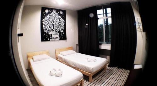 two beds in a small room with a window at De Chukai Hotel in Cukai