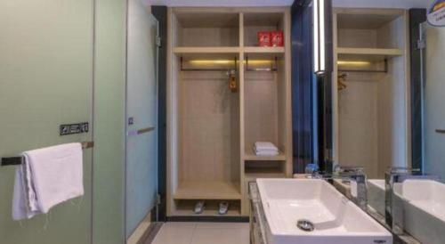 a bathroom with a sink and a shower and a mirror at Echarm Hotel Taizhou International Convention and Exhibition Center 