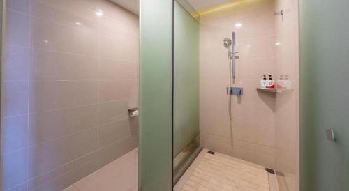 a shower with a glass door in a bathroom at Echarm Hotel Taizhou International Convention and Exhibition Center 