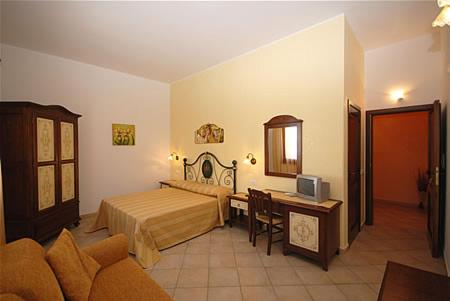 a bedroom with a bed and a desk with a computer at Kimos in San Vito lo Capo