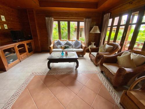 a living room with couches and a coffee table at Baan Laem Noi Villa's in Mae Nam
