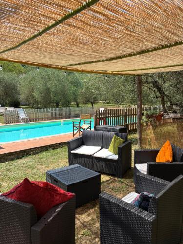 a patio with couches and chairs under a pergola at Agriturismo Le Pozze in Dicomano