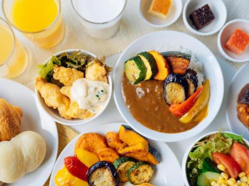 a table with plates of food and bowls of dips at Hotel Areaone Miyazaki in Miyazaki