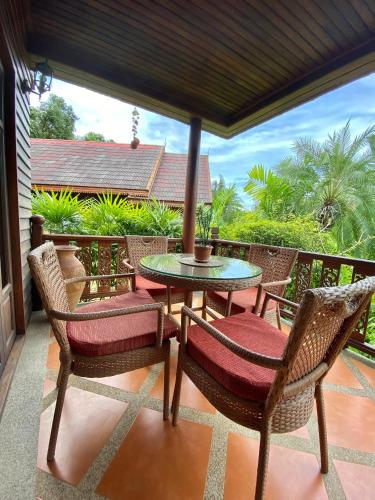 a patio with chairs and a table on a balcony at Baan Laem Noi Villa's in Mae Nam