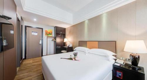 a large white bed in a hotel room at Zhuhai Aqueen Hotel in Zhuhai