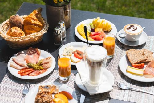 a picnic table with plates of food and drinks at Charme Hotel Barbatè in Tegna