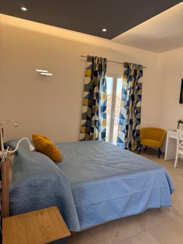 a bedroom with a blue bed with a yellow pillow at Casa MaLù in Aci Bonaccorsi