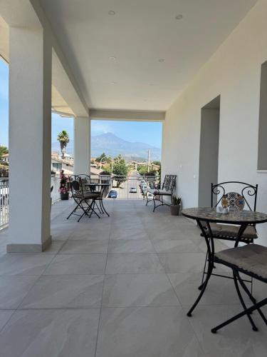 a patio with chairs and tables and a view at Casa MaLù in Aci Bonaccorsi