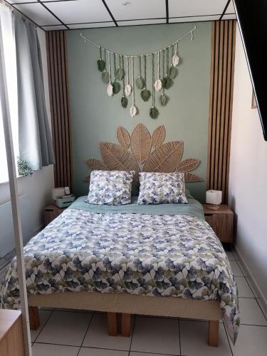 a bedroom with a bed with a flower headboard at Le Tiot Saint Martin in Auxi-le-Château