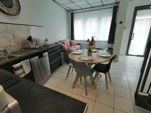 a kitchen with a table and chairs in a kitchen at Le Tiot Saint Martin in Auxi-le-Château