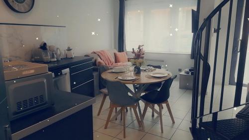 a small kitchen with a table and chairs in it at Le Tiot Saint Martin in Auxi-le-Château