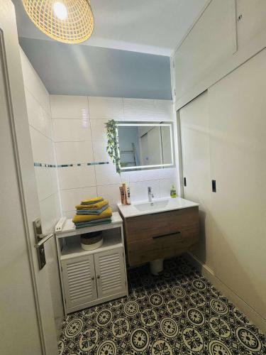 une salle de bain avec un lavabo et un miroir dans l'établissement Le 21 Avenue de Champagne, à Épernay