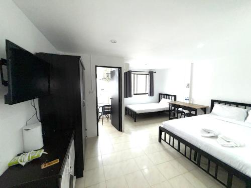 a bedroom with two beds and a living room at Patong Canal Villa R308 in Patong Beach
