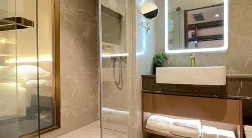 a bathroom with a sink and a shower at Chaozhou Hotel in Chaozhou