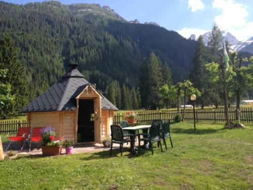 a gazebo with a table and chairs in a yard at Hotel Stella Alpina in Falcade
