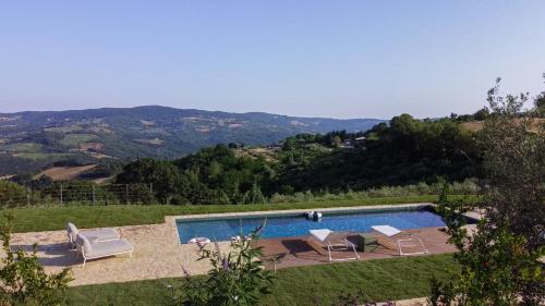 a swimming pool with two lounge chairs at L'edicola di Ripalvella in San Venanzo