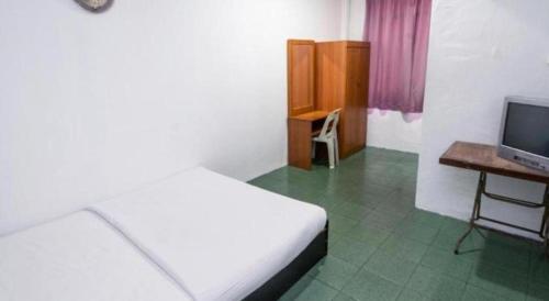 a bedroom with a bed and a desk and a television at OYO 89706 To-day Hotel in Sibu