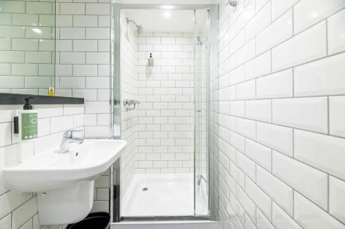 a white bathroom with a sink and a shower at easyHotel Newcastle in Newcastle upon Tyne
