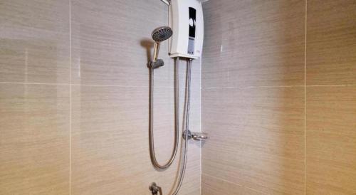 a shower with a shower head in a bathroom at Station 203 Hotel in Bangkok