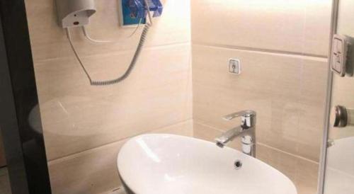 a bathroom with a sink and a phone on the wall at 7 Days Premium Hotel Ji'an Taihe Gongnongbing Avenue in Ji'an