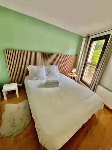 une chambre avec un grand lit blanc avec une fenêtre dans l'établissement Cosy a 3 min de la plage avec parking privé, à Cannes