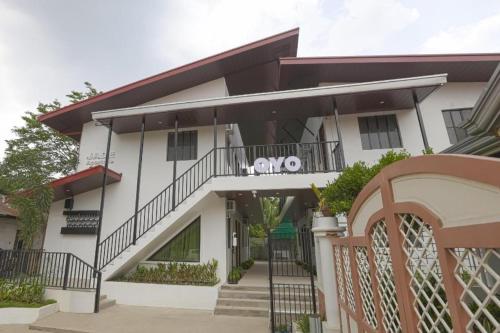 a white building with a balcony and a gate at OYO 736 Jade Apartelle in Calamba